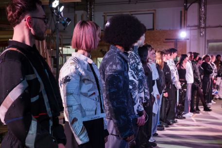 Reihe Models mit bunten Patch-Outfits auf einer Bühne