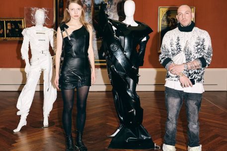 Model, Designer und zwei Puppen mit Outfits