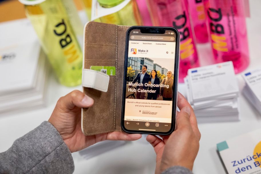Handy mit der Startseite des Munich Onboarding Hub Kalenders