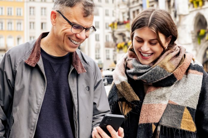 Stadterleben Webapp © Bert Willers, LHM Mann und Frau auf dem Marienplatz im Gespräch und mit einem Handy