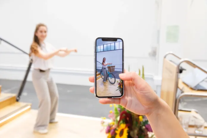 Handy fotografiert eine Person und visualisiert zugleich ein Fahrrad dazu