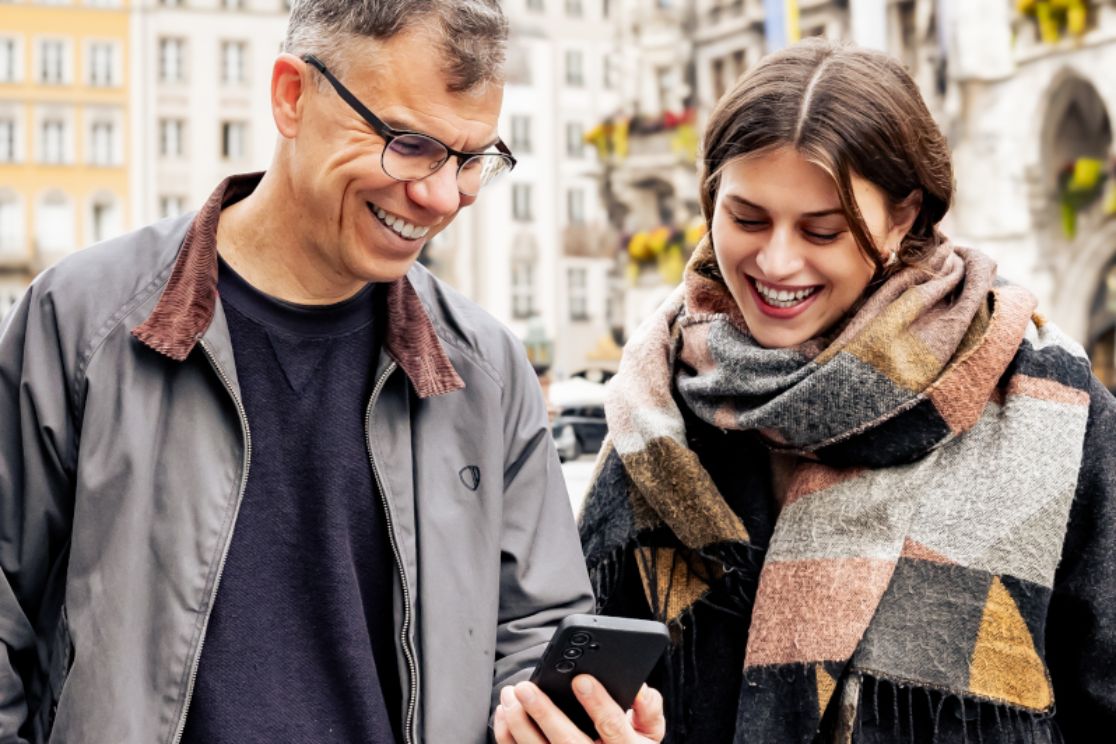 Mann und Frau auf dem Marienplatz im Gespräch und mit einem Handy