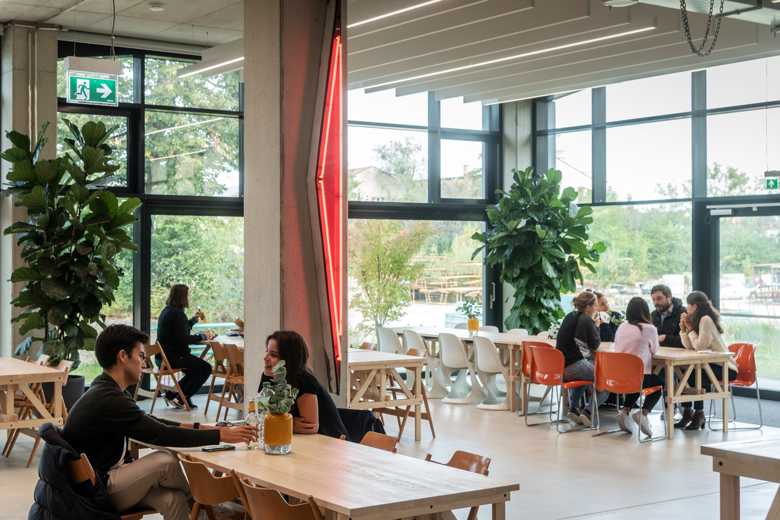 Munich Urban Colab - Blick in die Cafeteria mit mehreren Gästen, die an den Tischen sitzen