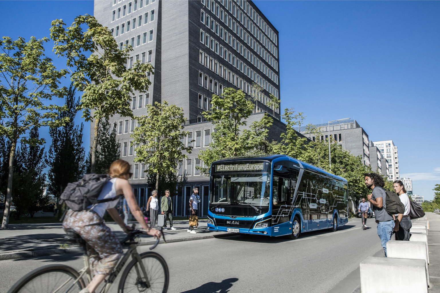 MVG-Bus, Radfahrerin und Fußgänger vor Google Kontor Haus, Erika-Mann-Straße, München